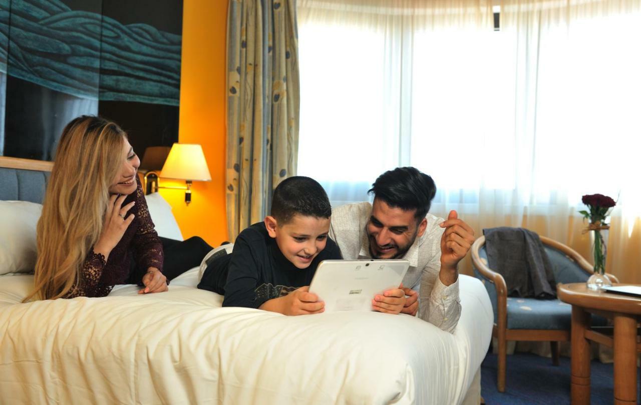 โรงแรมแกรนด์โฮเต็ลเมอร์คูเร่อัลเจอร์ แอร์โร่พอร์ท Maison Blanche ภายนอก รูปภาพ Family using a tablet