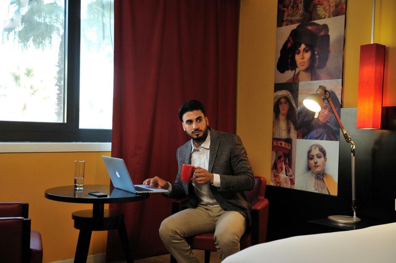 โรงแรมแกรนด์โฮเต็ลเมอร์คูเร่อัลเจอร์ แอร์โร่พอร์ท Maison Blanche ภายนอก รูปภาพ A man working on a laptop